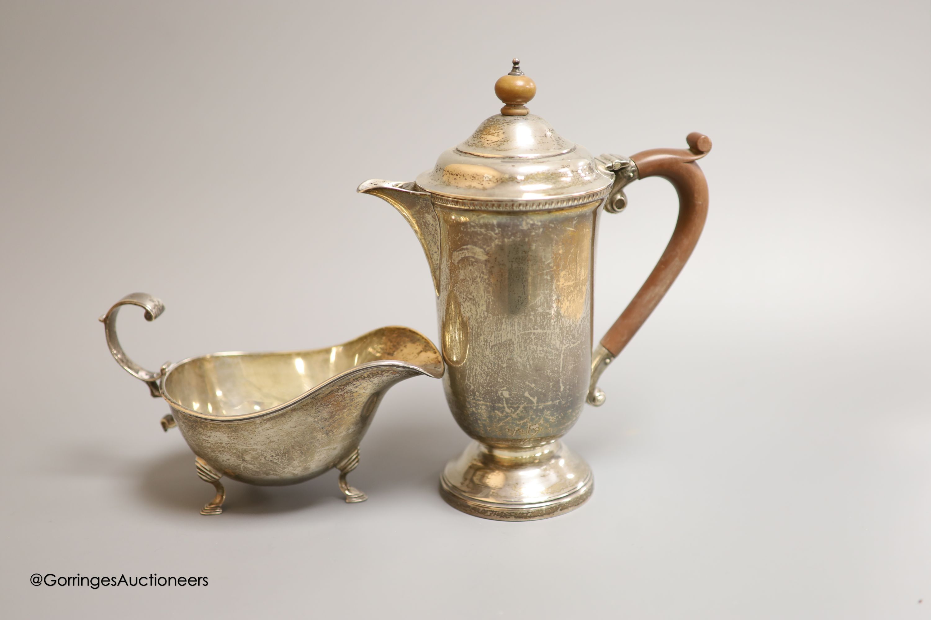 A cased pair of ornate Edwardian silver preserve spoons, Sheffield, 1905, a silver sauceboat, a silver hot water pot and two silver condiments